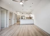 Thumbnail 17 of 31 - the living room and kitchen of a new home with white walls and wood flooring at The Falstaff, Raleigh, 27610