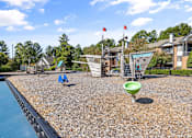 Thumbnail 39 of 50 - A playground with a slide and a green ball on the ground.