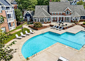 Thumbnail 26 of 45 - A large swimming pool surrounded by lounge chairs and a house.