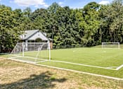 Thumbnail 42 of 50 - A soccer field with a goal post and a house in the background.
