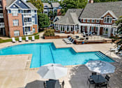 Thumbnail 29 of 45 - A large swimming pool surrounded by lounge chairs and umbrellas.