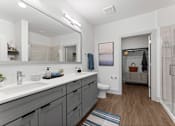 Thumbnail 6 of 25 - A bathroom with a white sink and a toilet.