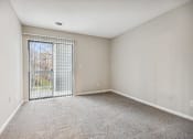 Thumbnail 42 of 44 - an empty living room with a large window and carpeting at Wendover River Oaks, North Carolina