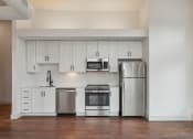 Thumbnail 9 of 46 - an empty kitchen with white cabinets and stainless steel appliances