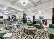 Thumbnail 29 of 46 - a lobby with green couches and chairs and a black and white checkered floor
