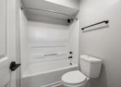 Thumbnail 37 of 67 - A white toilet sits next to a bathtub in a small bathroom.
