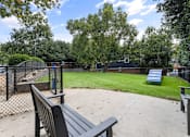 Thumbnail 39 of 45 - A park with a bench and a fence.