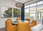 Thumbnail 13 of 31 - A dining room with a table surrounded by chairs and two paintings on the wall.