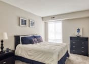 Thumbnail 28 of 52 - a bedroom with a bed and a dresser and a window at Bayville Apartments, Virginia