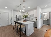 Thumbnail 2 of 25 - A modern kitchen with a white island and bar stools.