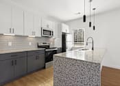 Thumbnail 6 of 51 - A kitchen with a granite countertop and dark grey cabinets.