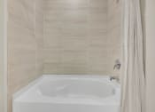 Thumbnail 6 of 35 - a bathroom with a bath tub and a shower curtain at The Enclave at Deer Moss Creek, Florida