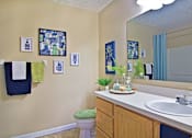 Thumbnail 6 of 21 - A bathroom with a toilet, sink, and a mirror.
