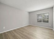 Thumbnail 41 of 67 - A room with a window and wooden flooring.