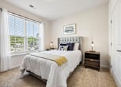 Thumbnail 43 of 51 - A bedroom with a large bed and a window with white curtains.