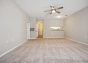 Thumbnail 11 of 46 - a spacious living room with carpet and a ceiling fan