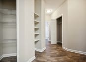 Thumbnail 7 of 46 - a walk in closet with shelves and a closet door and a door to a hallway