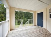 Thumbnail 17 of 46 - a covered porch with a blue door and a view of trees
