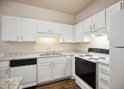 Thumbnail 1 of 46 - a kitchen with white cabinets and black appliances and white counter tops
