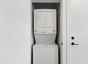 Thumbnail 7 of 44 - A white washing machine is sitting in a white door.