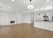 Thumbnail 7 of 51 - A modern kitchen with a fireplace and wooden floors.