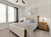 Thumbnail 7 of 35 - a bedroom with a bed and a ceiling fan at The Enclave at Deer Moss Creek, Niceville, FL, 32578