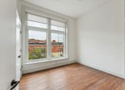 Thumbnail 5 of 46 - an empty living room with a large window and wood floors