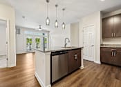 Thumbnail 27 of 51 - A kitchen with a stainless steel dishwasher and wooden floors.