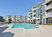 Thumbnail 49 of 51 - A swimming pool is surrounded by apartment buildings.