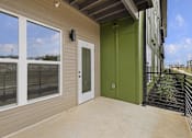 Thumbnail 8 of 44 - A balcony with a green door and a black railing.