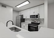 Thumbnail 42 of 67 - A kitchen with a sink, stove, and refrigerator.