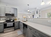 Thumbnail 2 of 45 - A modern kitchen with a stainless steel oven and microwave.