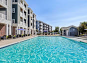 Thumbnail 50 of 51 - A swimming pool in front of apartment buildings.