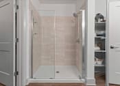 Thumbnail 7 of 25 - A white bathroom with a walk-in shower and a cabinet with shelves.