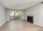 Thumbnail 43 of 67 - A spacious living room with a fireplace and sliding glass doors.