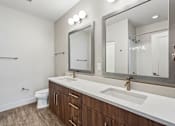 Thumbnail 62 of 64 - A bathroom with a white sink and a large mirror.