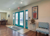 Thumbnail 4 of 52 - a living room with turquoise doors and a table with chairs at Bayville Apartments, Virginia Beach, Virginia
