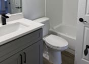 Thumbnail 39 of 56 - A white toilet sits in a bathroom next to a white sink.