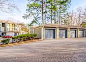 Thumbnail 10 of 20 - A parking lot with a building and a tree in the background.