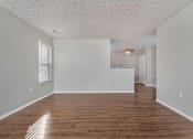 Thumbnail 10 of 28 - A room with wooden floors and white walls.