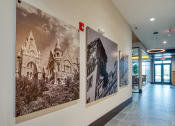 Thumbnail 26 of 38 - a hallway with large pictures on the wall and a lobby door at Aura Stonebridge, Richmond