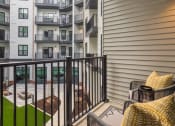 Thumbnail 6 of 38 - our apartments have a private balcony with chairs and a table at Aura Stonebridge, Virginia