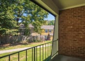 Thumbnail 38 of 39 - a porch with a brick wall and a black railing