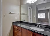 Thumbnail 10 of 33 - A bathroom with a toilet, sink, and mirror.
