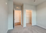 Thumbnail 5 of 42 - an empty bedroom with a closet and a door to a bathroom at The Bella at Westchester, Midlothian, VA
