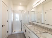 Thumbnail 26 of 81 - a bathroom with granite countertops and a large mirror at Ainsworth, Richmond