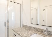 Thumbnail 28 of 81 - a bathroom with a sink and a shower with a glass door at Ainsworth, Virginia