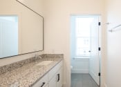 Thumbnail 36 of 81 - a bathroom with granite countertops and a large mirror at Ainsworth, Richmond, Virginia