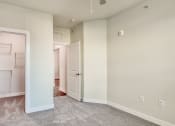 Thumbnail 6 of 42 - an empty room with a closet and a door to a laundry room at The Bella at Westchester, Midlothian, 23113