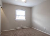 Thumbnail 13 of 31 - A room with a window and carpeted floor.